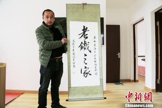 阿木爾林業(yè)局網(wǎng)紅劉老四展示粉絲贈送的“老鐵之家”書法作品。(王力攝)